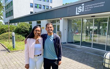 VfL-Profi Cristian Gamboa mit DaF-Lehrerin Caroline Gnanko vor dem Eingang des LSI